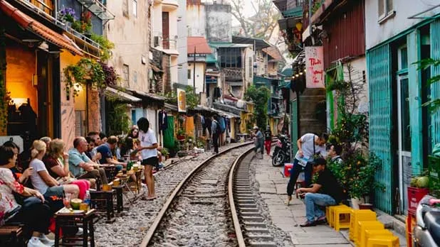 Tourists enjoying coffee at cafes along Hanoi Train Street, Honeymoon in Vietnam.