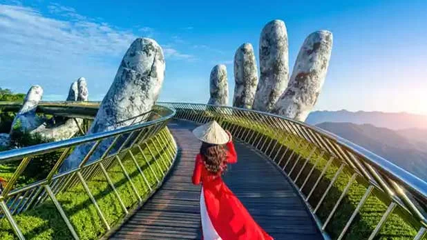 A woman is walking on the Golden Bridge held by giant stone hands in Da Nang, Vietnam honeymoon package from India